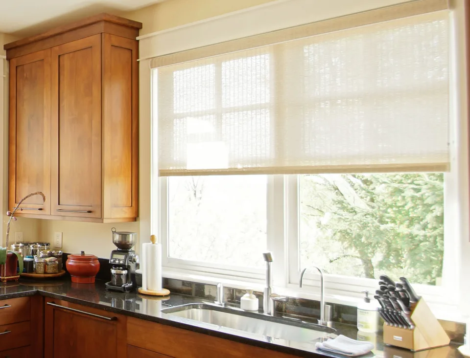 Textured cream Insolroll roller shade above a kitchen window
