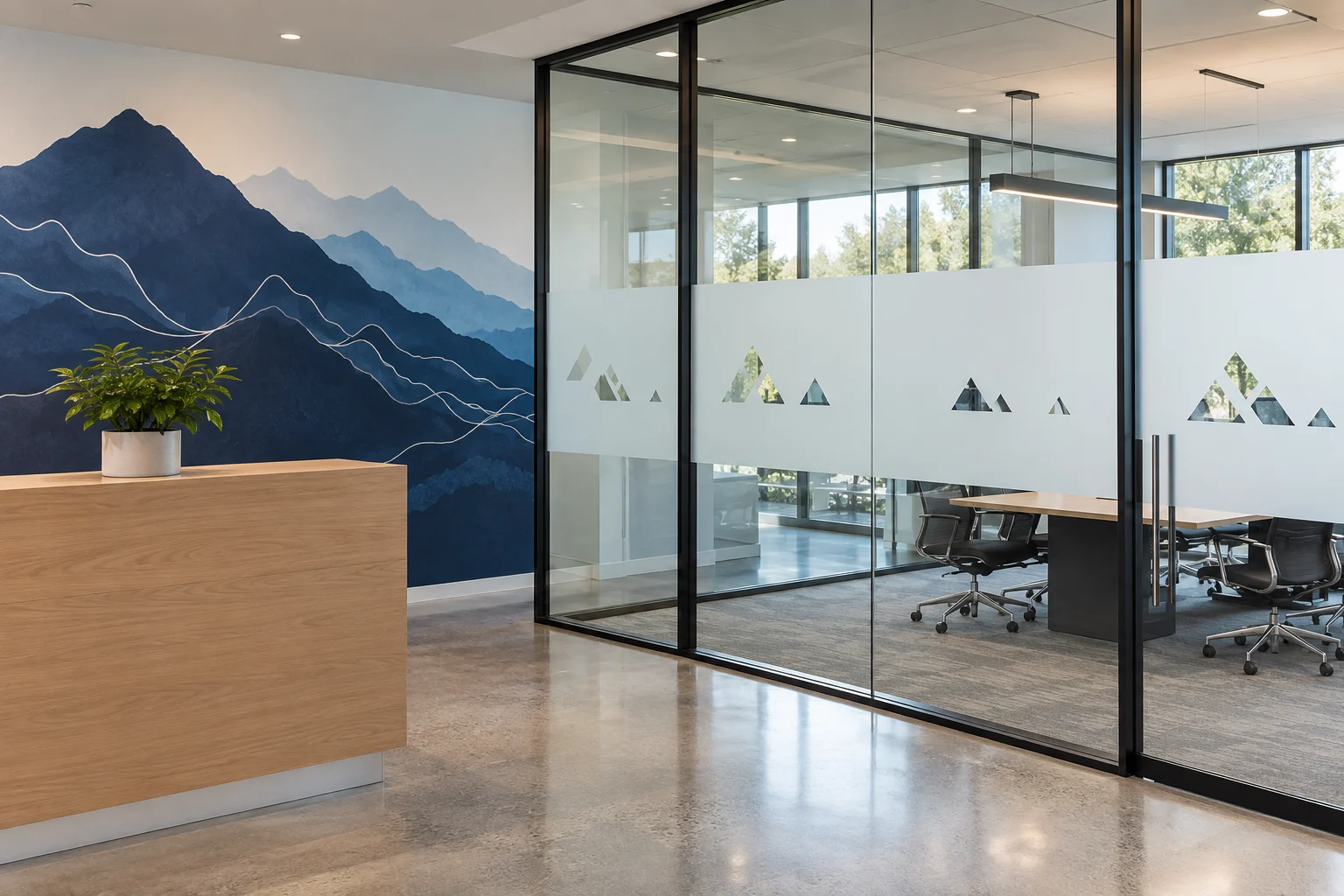 Concept office with frosted geometric privacy film and a blue mountain wall graphic