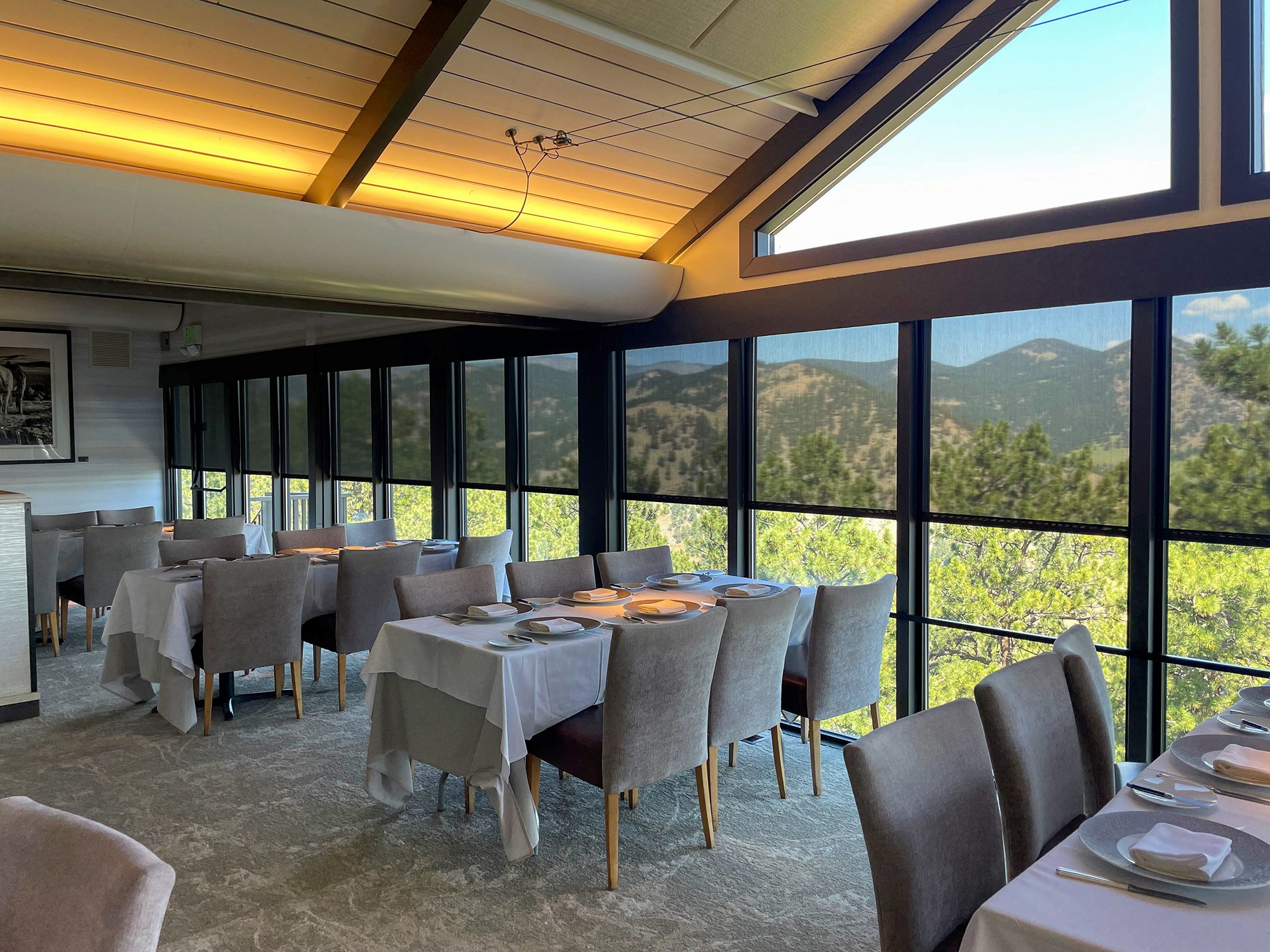 Manufacturer example: Insolroll solar screen shades across a window wall with mountain views